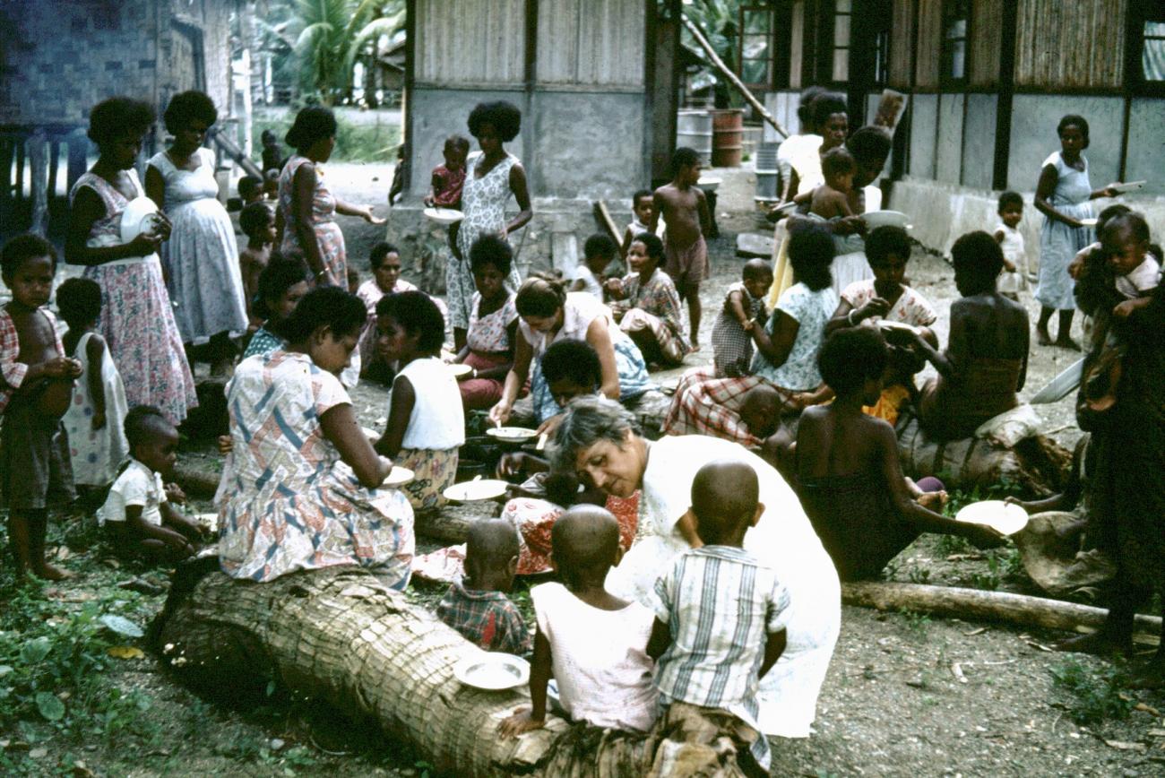 BD/289/65 - 
Groep vrouwen met kinderen zijn aan het eten
