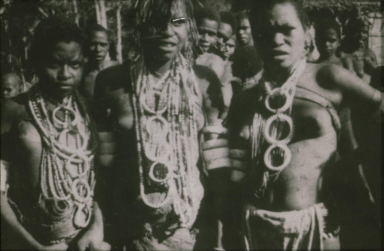 BD/309/154 - 
Drie vrouwen in traditionele kleding met halssieraden en armsieraden gemaakt van schelpen
