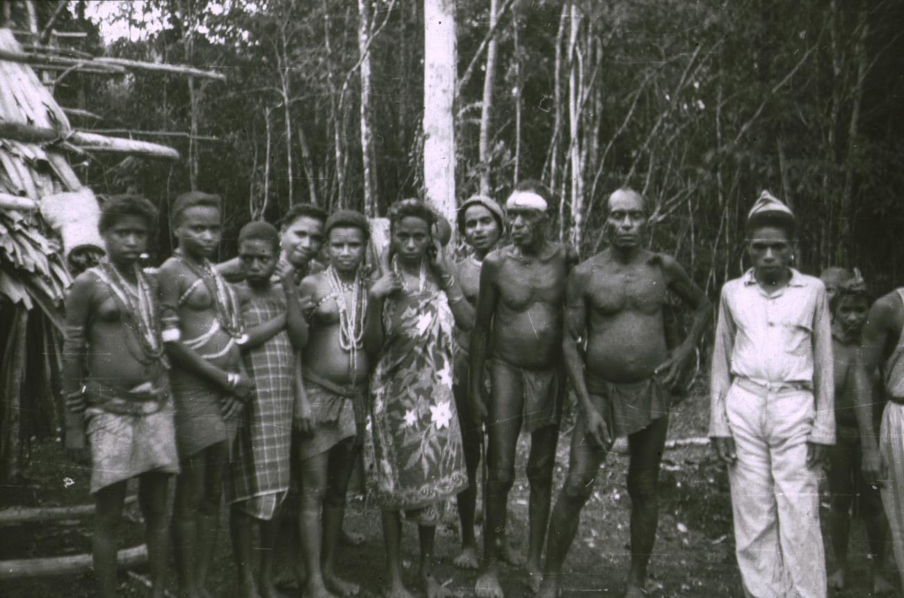 BD/309/155 - 
Groepsfoto van mannen en vrouwen in traditionele kleding met rechts de onderwijzer (guru) 
