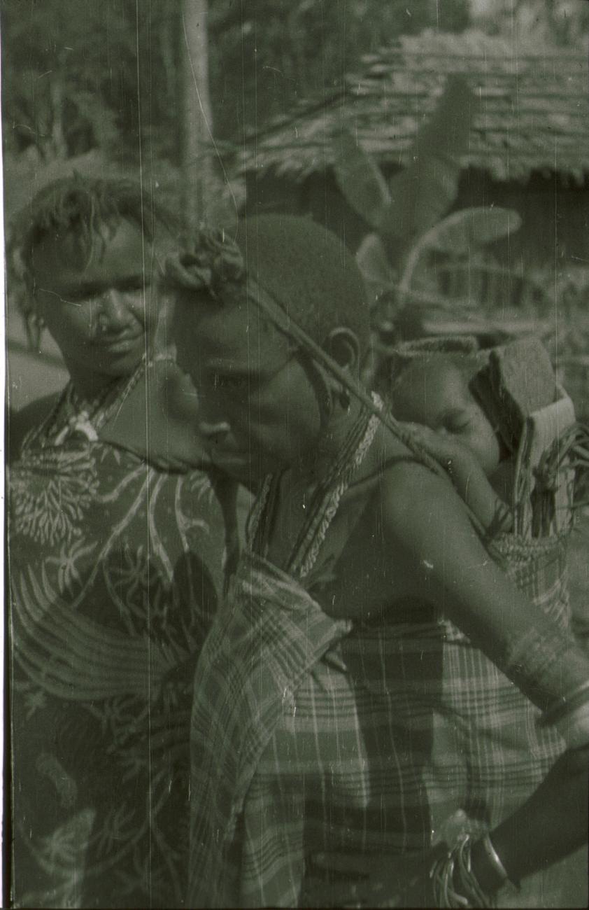 BD/309/172 - 
Twee vrouwen in kleding met halssieraden en baby op de rug gedragen 
