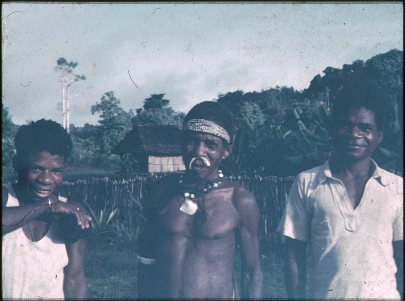BD/309/195 - 
Drie mannen waarvan een met traditionele hals- en neusversiering 

