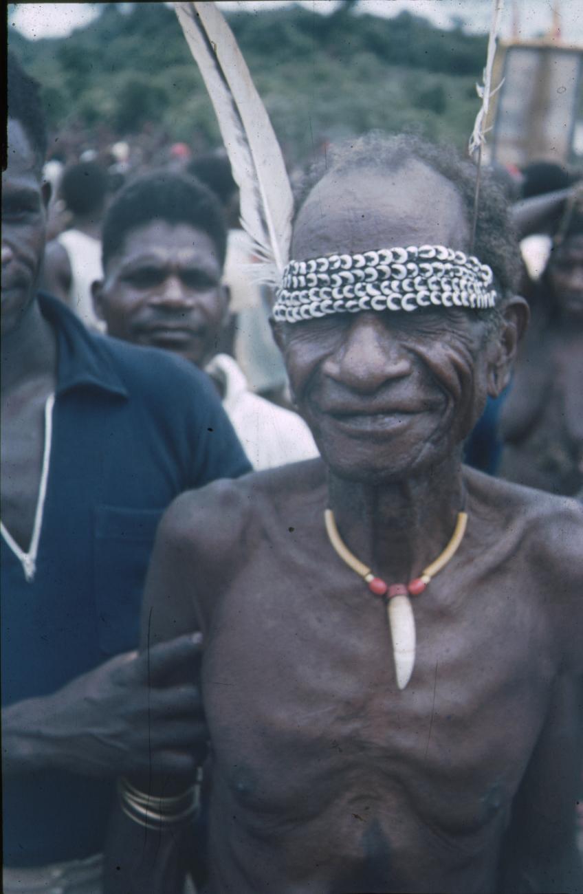 BD/309/196 - 
Man met armbanden, halsversiering en hoofdband met schelpen en veer
