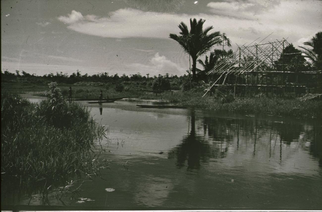 BD/309/211 - 
Landschap met rivier en prauwen en op de oever huis in aanbouw
