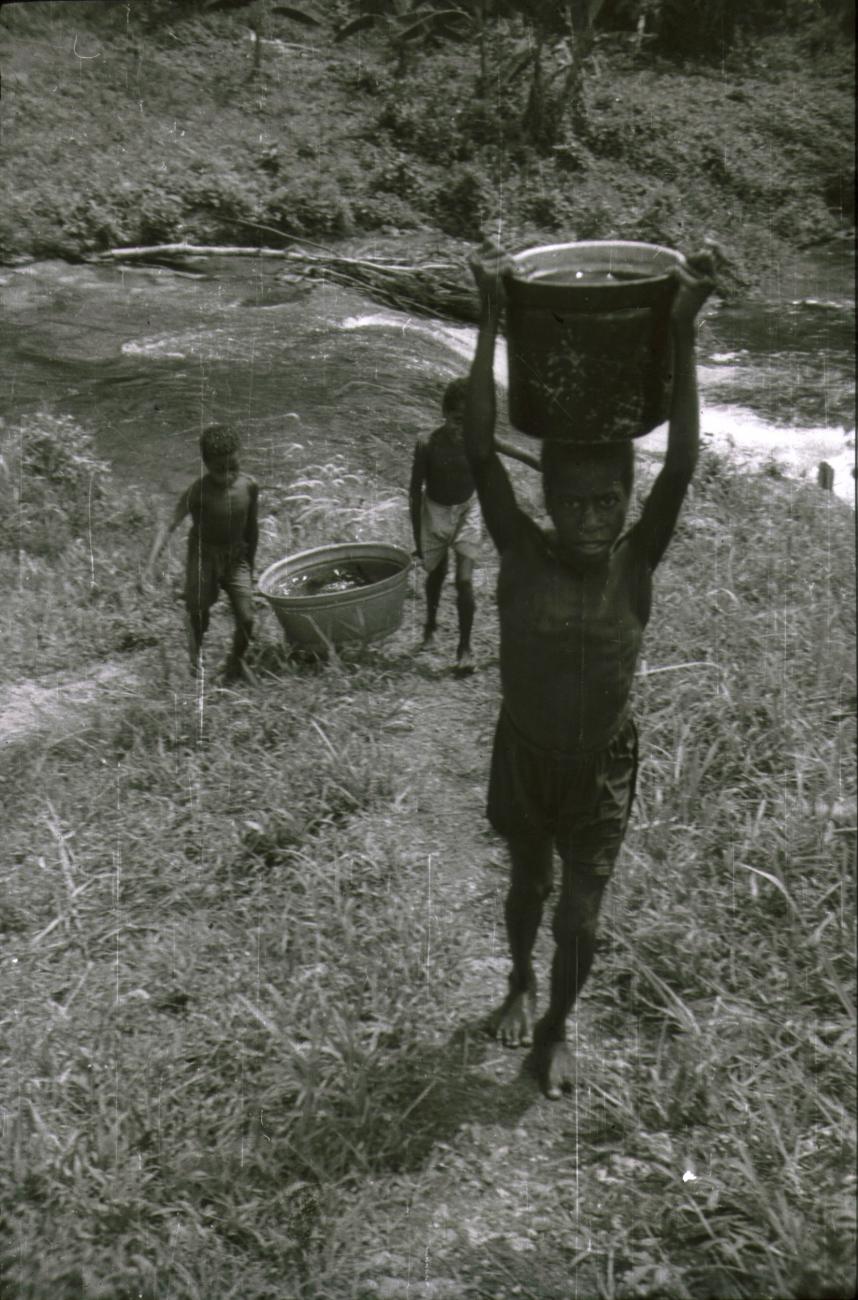 BD/309/226 - 
Leerlingen van de Jongens Vervolgschool JVVS in Teminabuan halen water uit de rivier 
