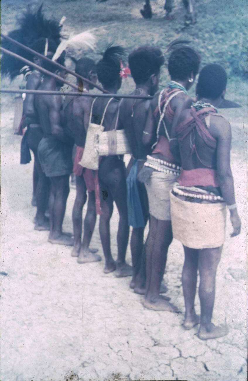 BD/309/276 - 
Mannen en vrouwen met hoofdtooi, kettingen, tassen, schelpenbanden en speren 
