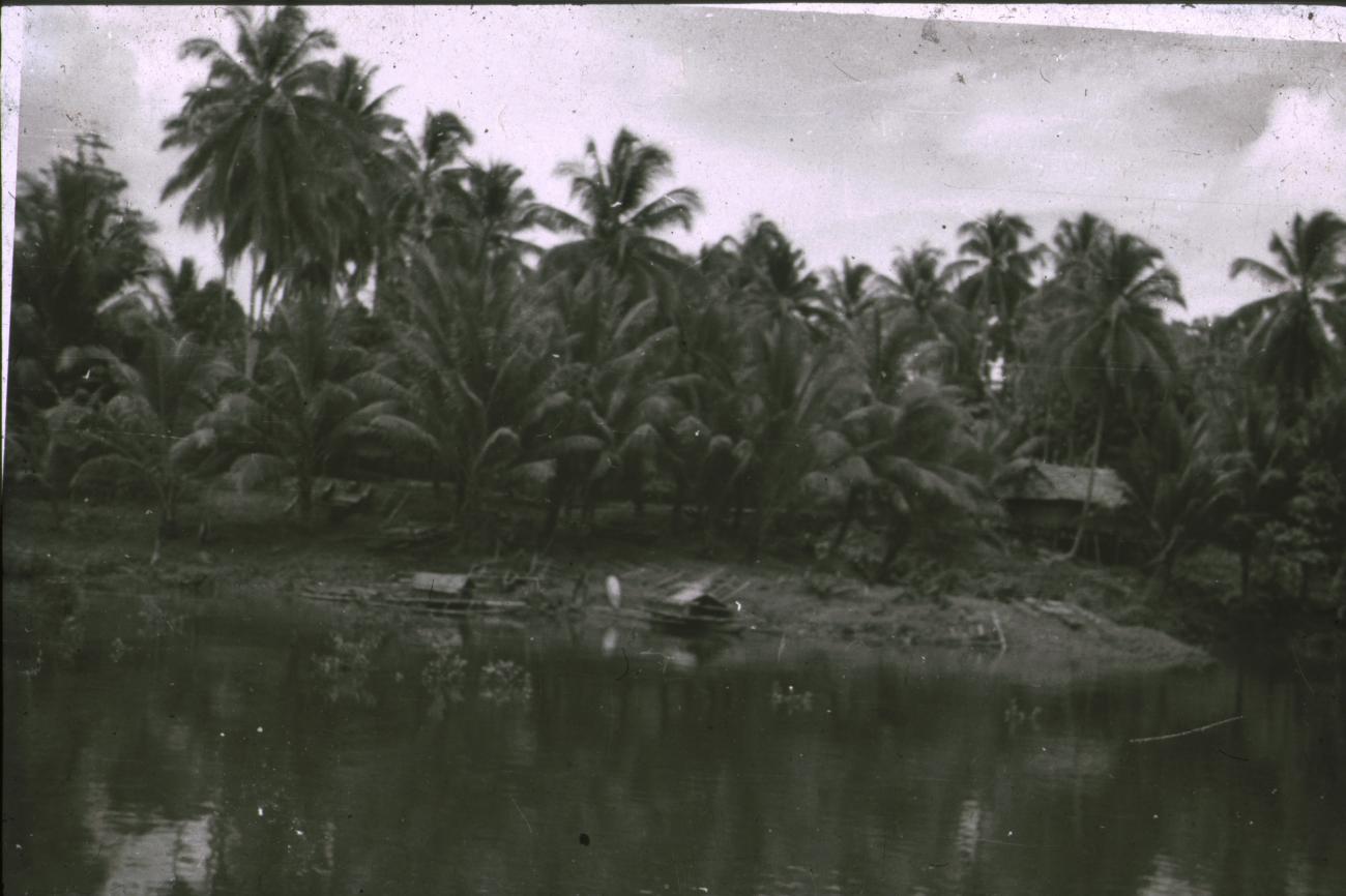BD/309/321 - 
Landschap van paalwoning en prauwen aan de rivier
