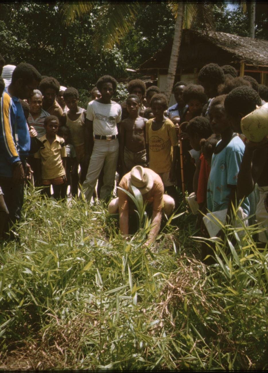 BD/309/337 - 
Dominee Marcus plant een nieuwe kokospalm in het dorp Konda
