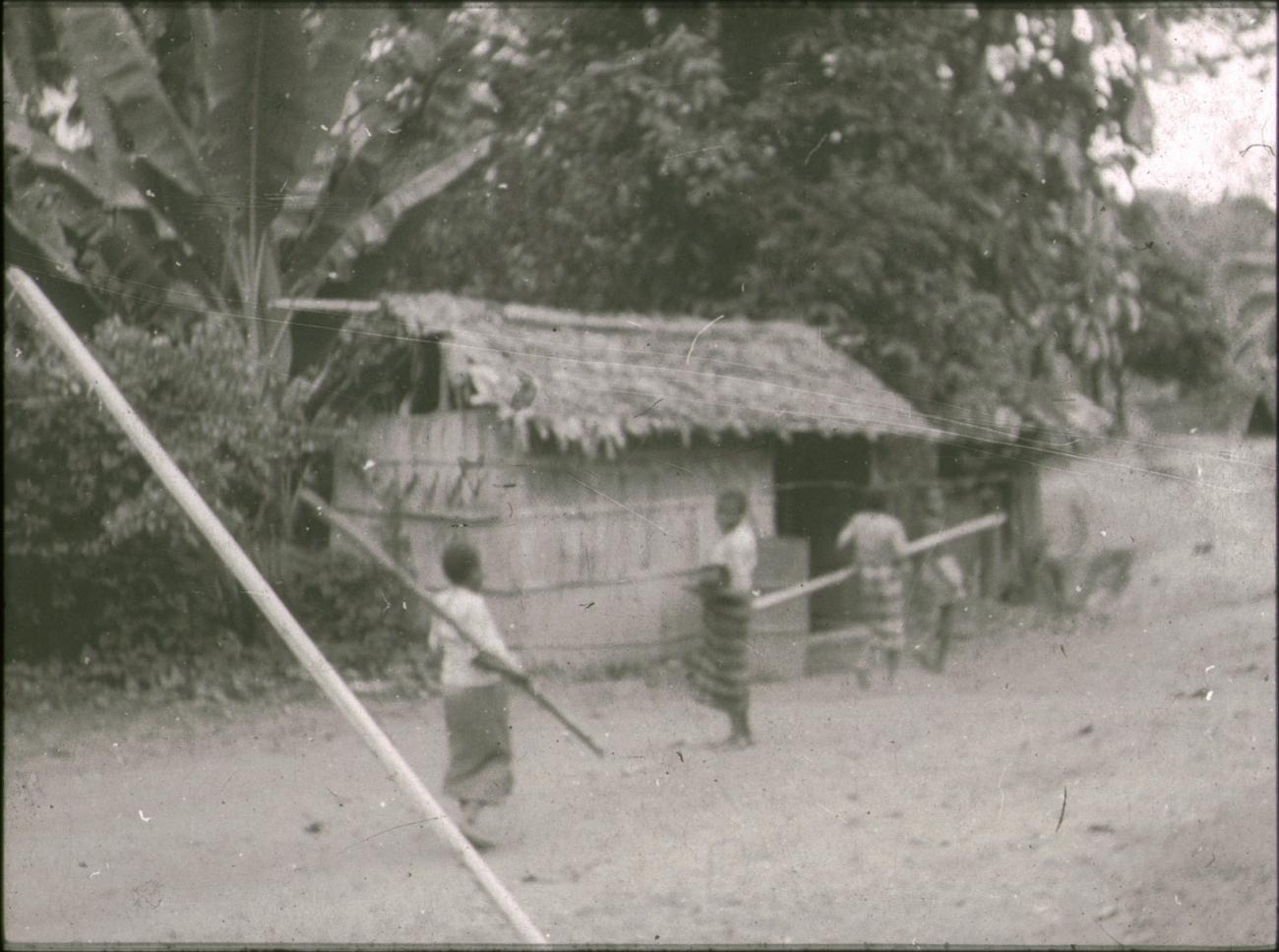 BD/309/369 - 
Drie vrouwen voor een traditionele woning in het dorp Wersar
