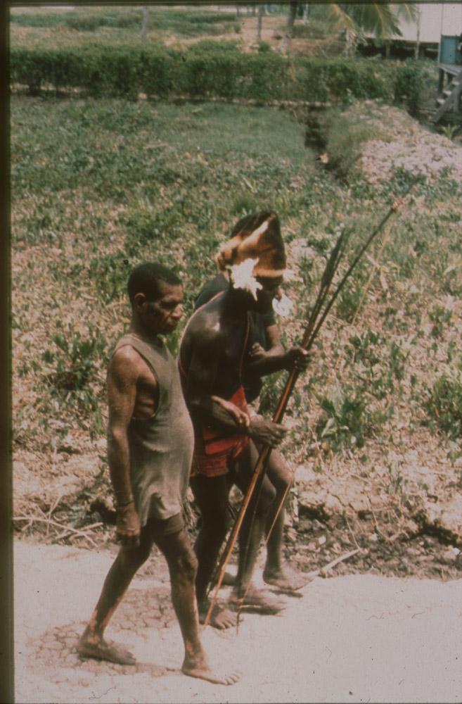 BD/30/73 - 
Asmat men walking on the street in the village
