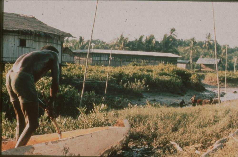 BD/30/91 - 
Asmatman hakt prauw uit op oever voor dorp
