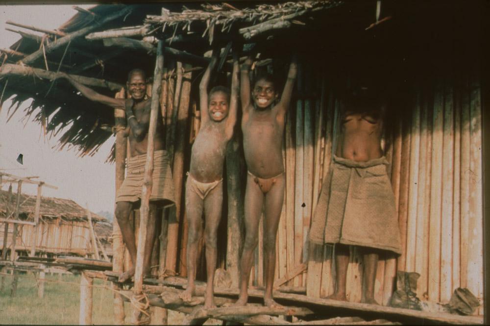 BD/30/97 - 
Asmatkinderen staan bovenop rand paalwoning in dorp
