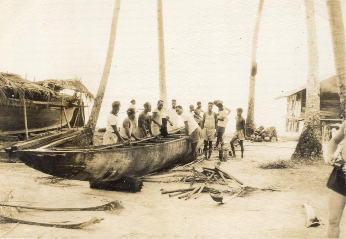 BD/318/113 - 
Het verplaatsen van een zeeprauw aan het strand van Biak 
