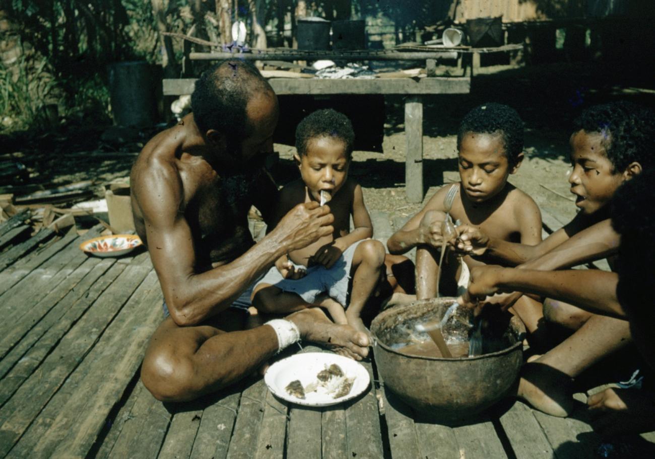 BD/66/115 - 
Vader met zijn zonen bij de maaltijd
