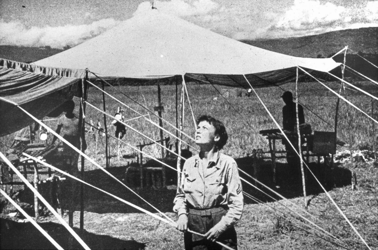 BD/66/258 - 
Bivak, westerse vrouw bezig met opzetten tent
