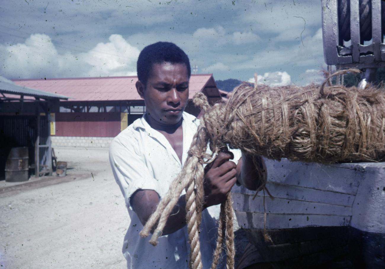 BD/66/33 - 
Man met touwen bij een boot aan kade
