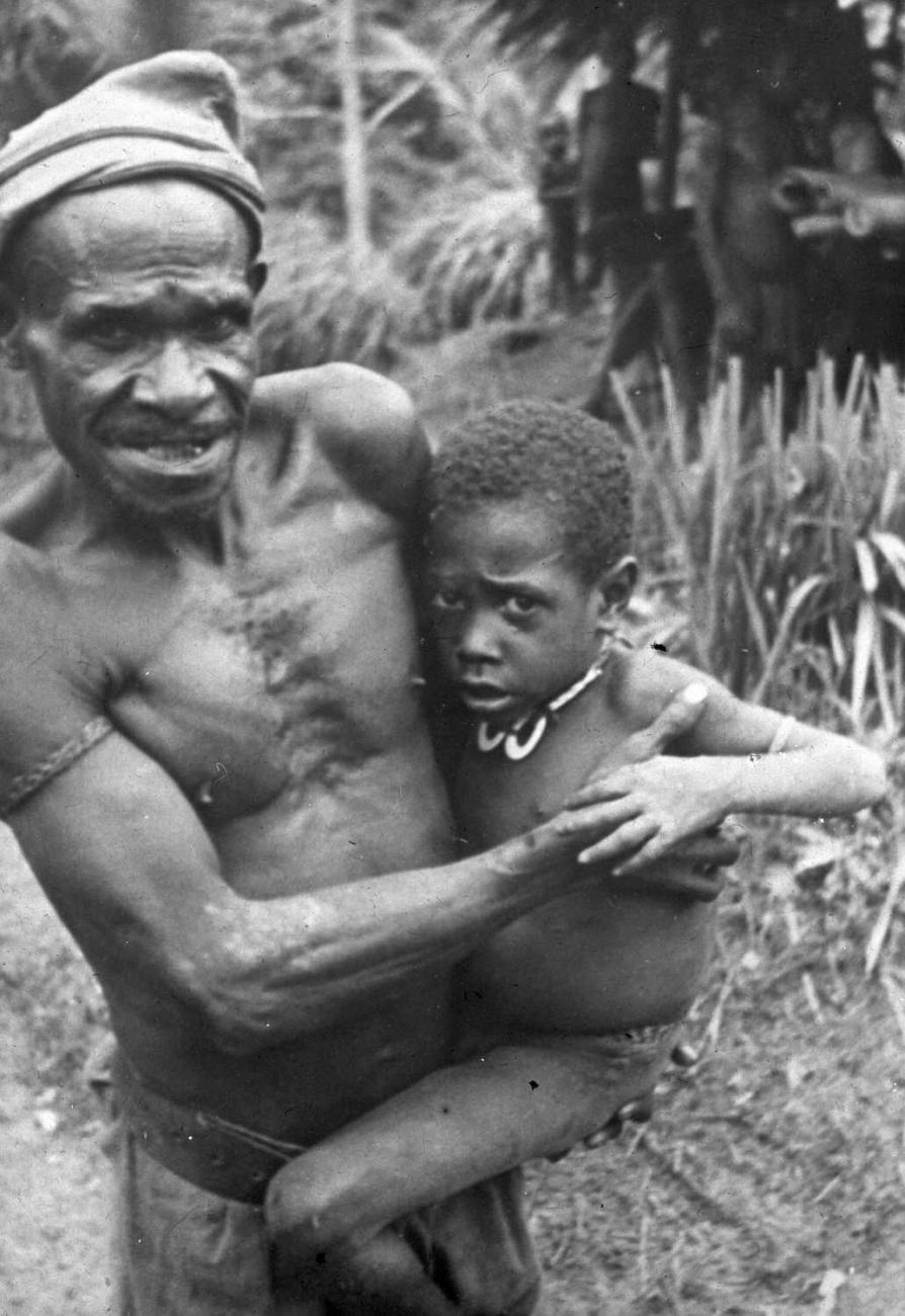 BD/66/450 - 
Portret van een Papoea-man met zijn kind op de arm
