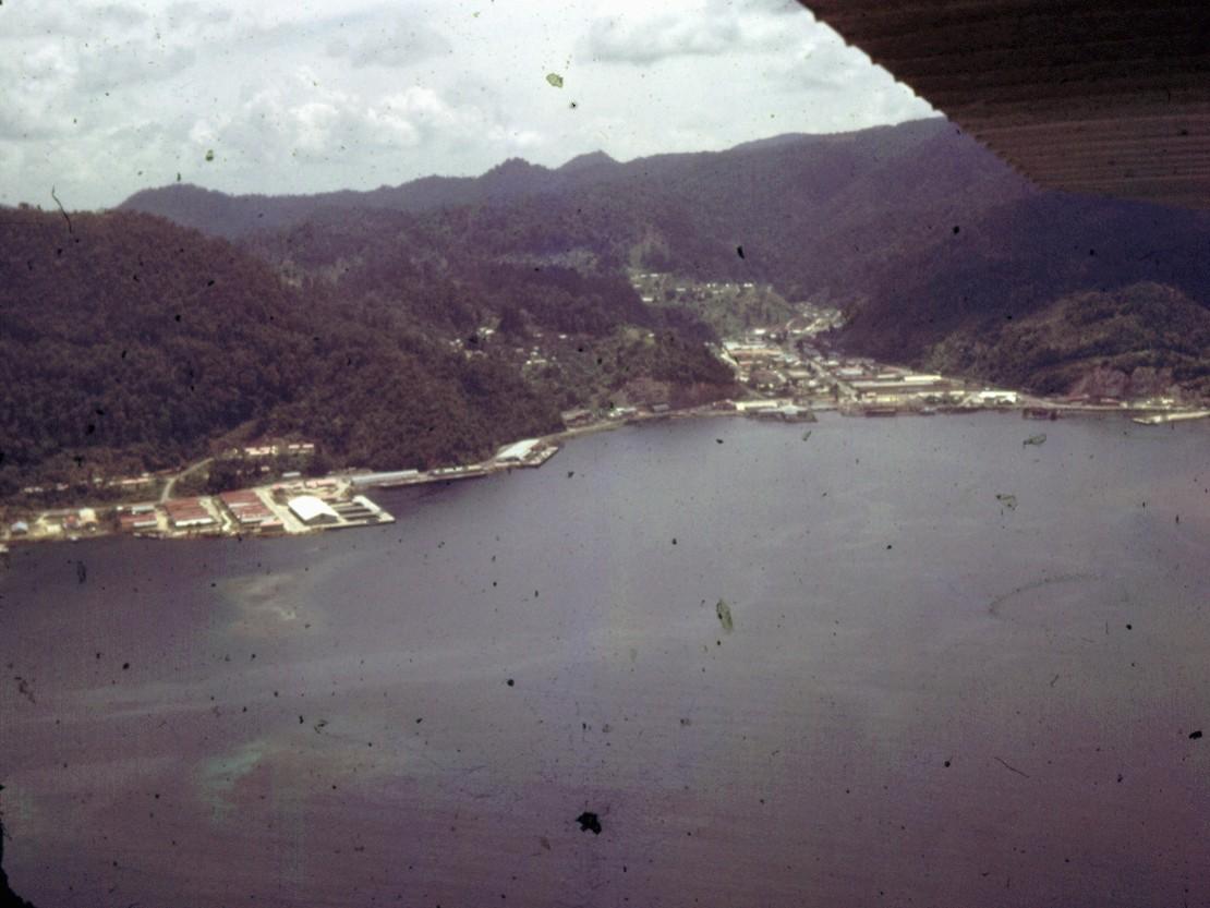 BD/66/50 - 
Luchtfoto van huizen en fabrieken bij een baai
