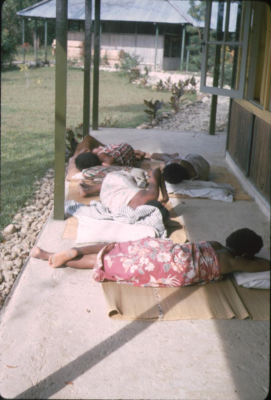 BD/171/103 - 
Meisjes rusten op rieten matjes.
