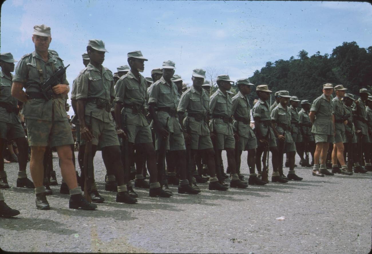 BD/171/159 - 
Koninginnendag, papoea vrijwilligers korps in de houding.
