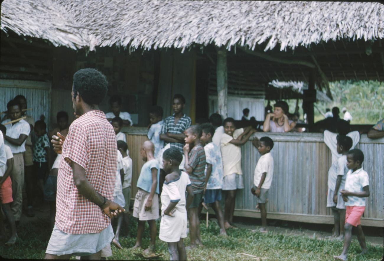 BD/171/23 - 
Groep mannen en kinderen die de bamboefluit bespelen.
