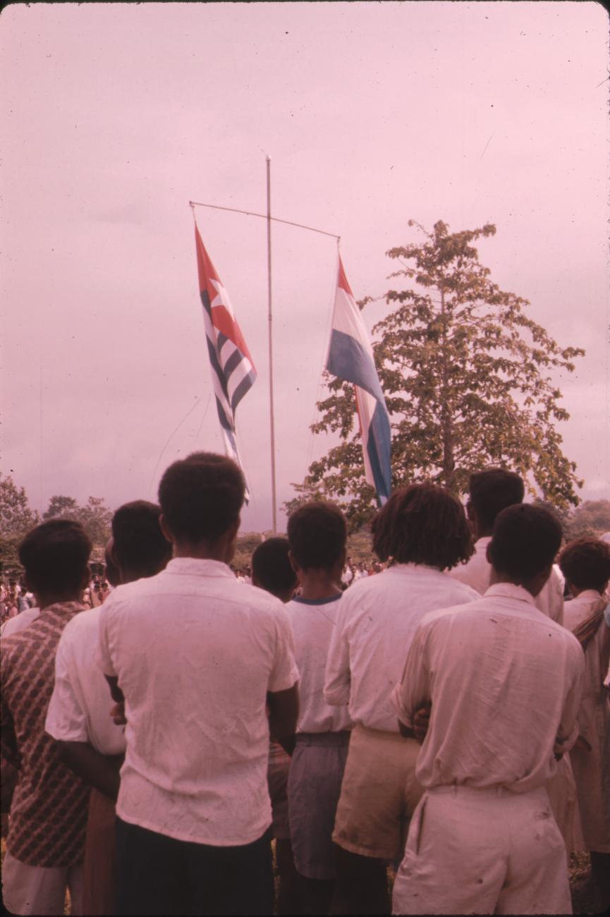 BD/171/24 - 
Festiviteit, vlaggenmast met Nederlandse vlag en Papoeavlag.
