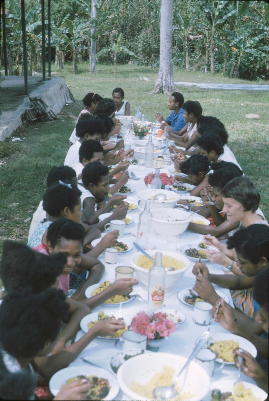 BD/171/361 - 
Jonge vrouwen en westerse vrouwen aan maaltijd in openlucht.
