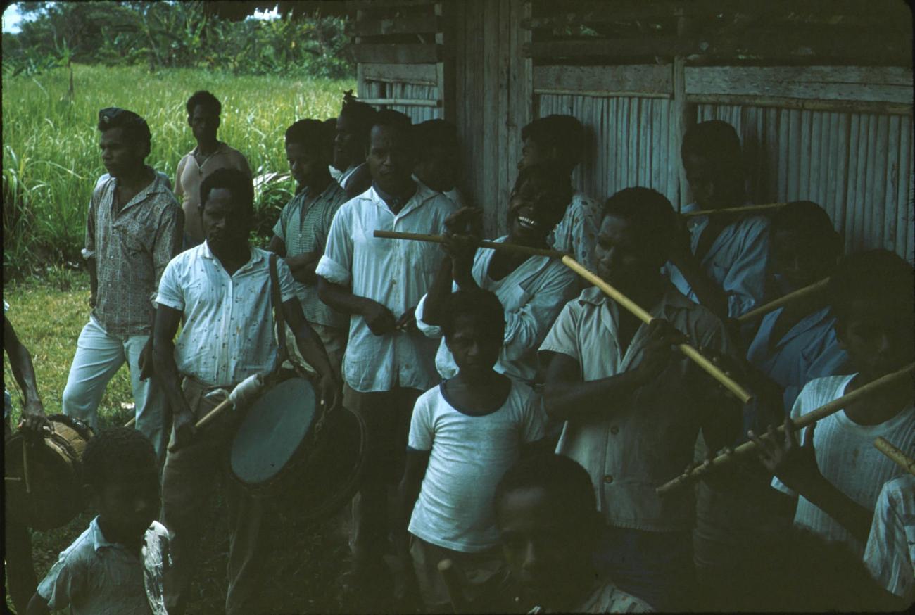 BD/171/57 - 
Groep mannen en jongens die de bamboefluit bespelen.
