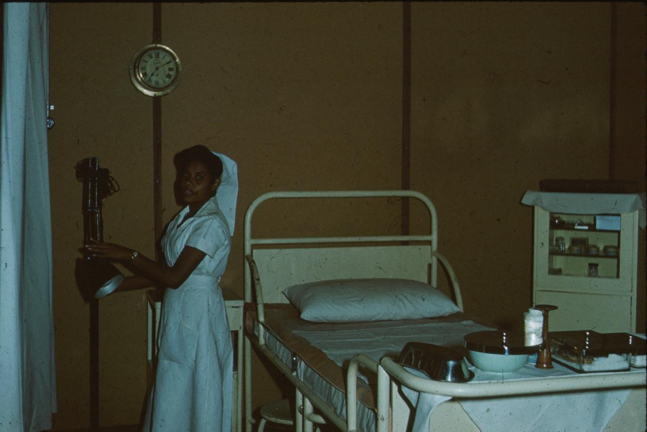 BD/171/867 - 
Verpleegster met leeg ziekenhuisbed 
