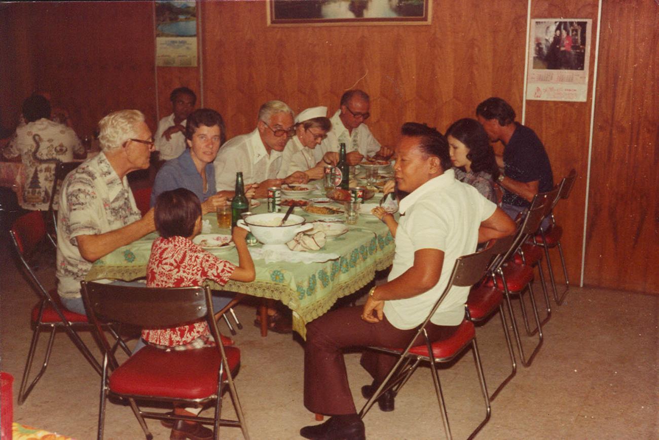 BD/269/1066 - 
Henk en Jan Blom aan tafel met mensen

