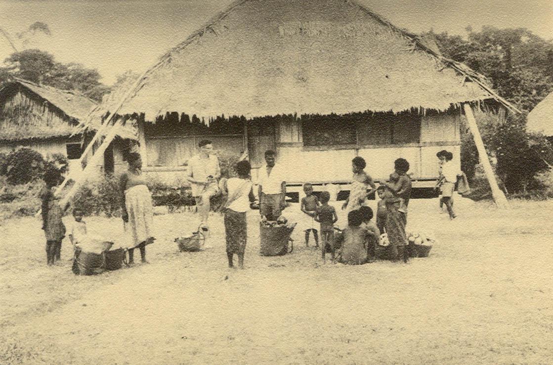 BD/269/1150 - 
Westerling en groep Papoea&#039;s met (handels)waar voor de pastorie in Arso
