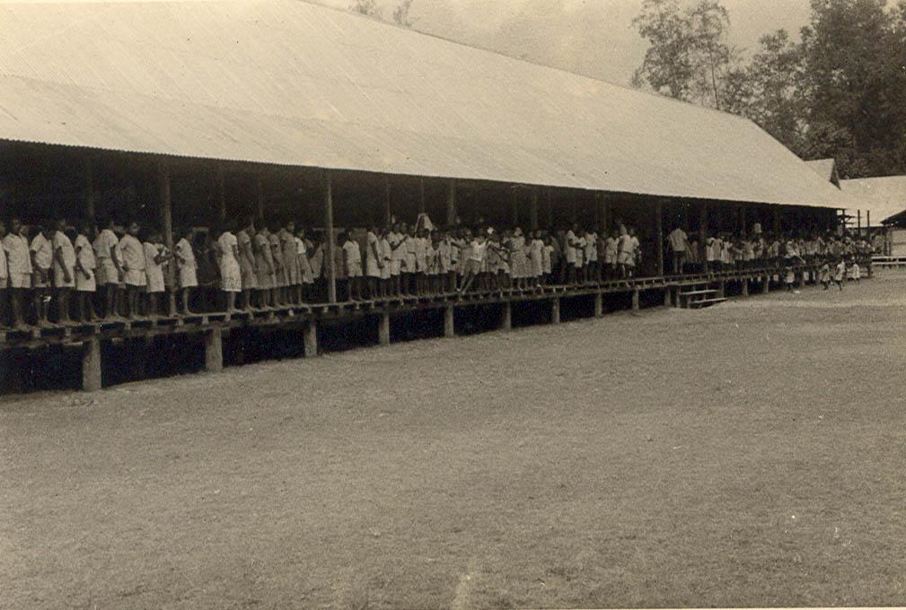 BD/269/1174 - 
Papoea-kinderen verzameld op de veranda van het internaat in Kokonau
