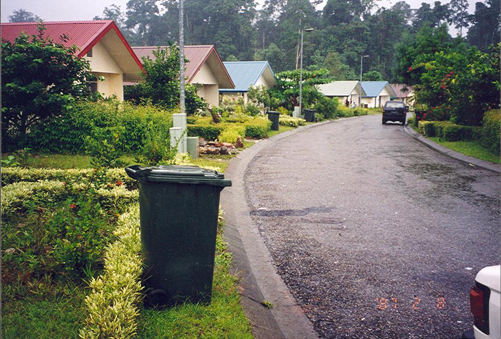 BD/269/1268 - 
Straatbeeld met bungalows en Kliko&#039;s in Kuala Kencana: suburbia in Papua
