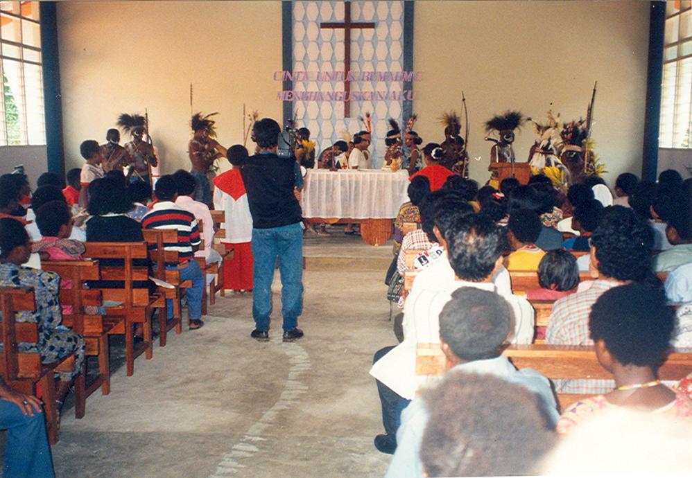 BD/269/807 - 
Katholieke kerkdienst met Papoeas op achtergrond
