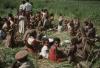 BD/132/224 groep vrouwen en kinderen eten, met op voorgrond een militair