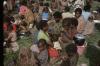 BD/132/249 vrouwen en kinderen met pannen en draagnetten in het gras