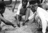 BD/133/1184 Papoea-mannen tekenen een kaart in het zand