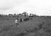BD/133/875 Groep Paoeavrouwen met kinderen op weg door het veld