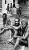 BD/277/12 Papoea mannen met op achtergrond een huis
