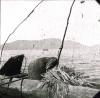 BD/329/16 Papoea  in de weer met een visnet, varend in een prauw op een meer 