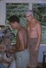 BD/209/9210 Opleidingskamp Papoea Vrijwilligers Korps: leerling slijpt schoenzool bij schoenmakerijmachine 