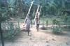 BD/309/370 Drie kinderen met op achtergrond paalwoningen in het dorp Wersar 