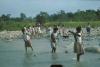 BD/171/100 Op een strandje vol keien bevinden zich vrouwen om het water in te gaan